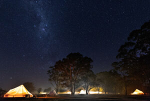 Glowing glamping site in the night, starry night camping