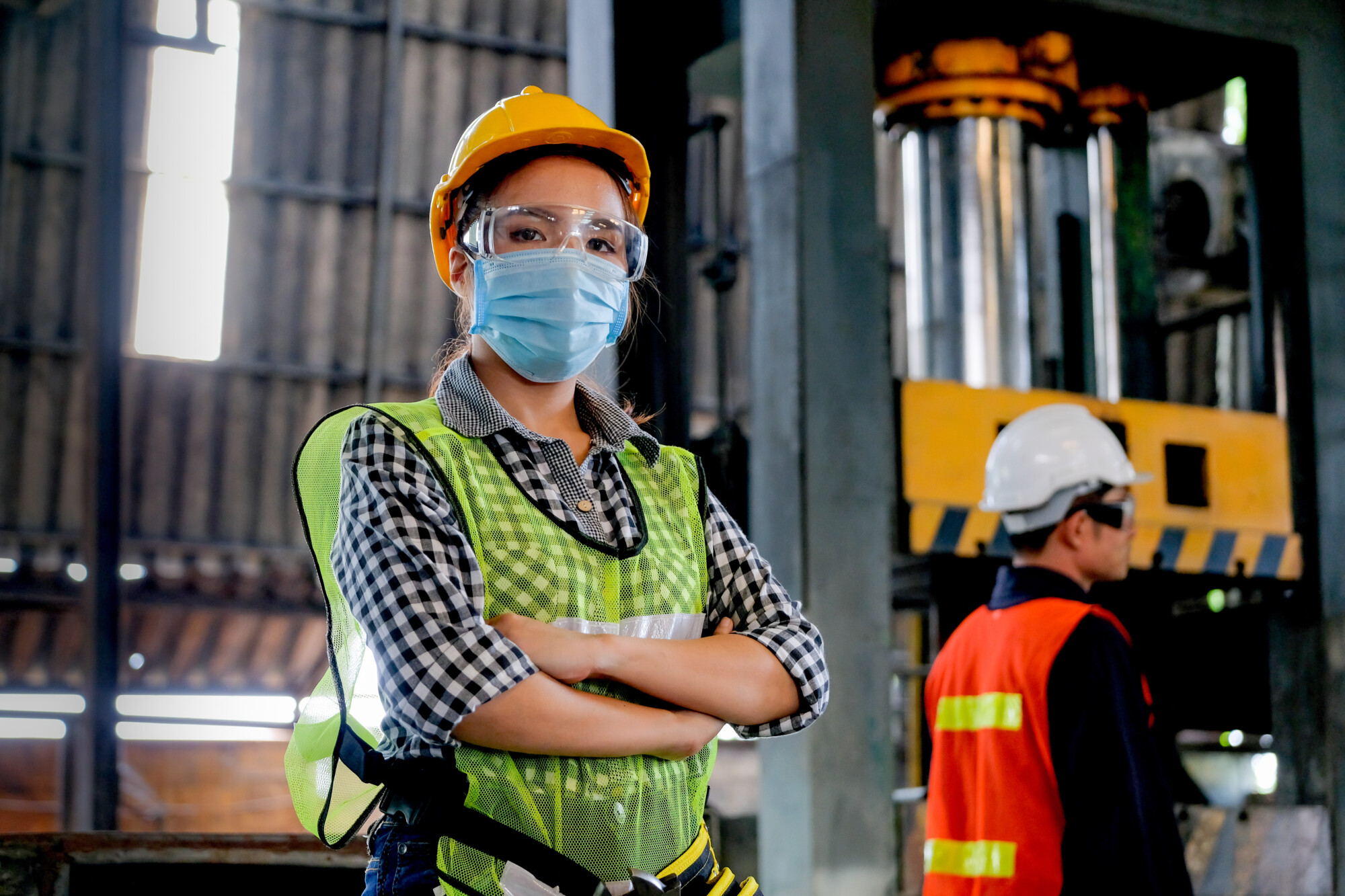 UK food Factory woman worker or technician with hygienic mask stand with confident action with her co-worker engineer in workplace during concern about covid pandemic in people affect industrial business.