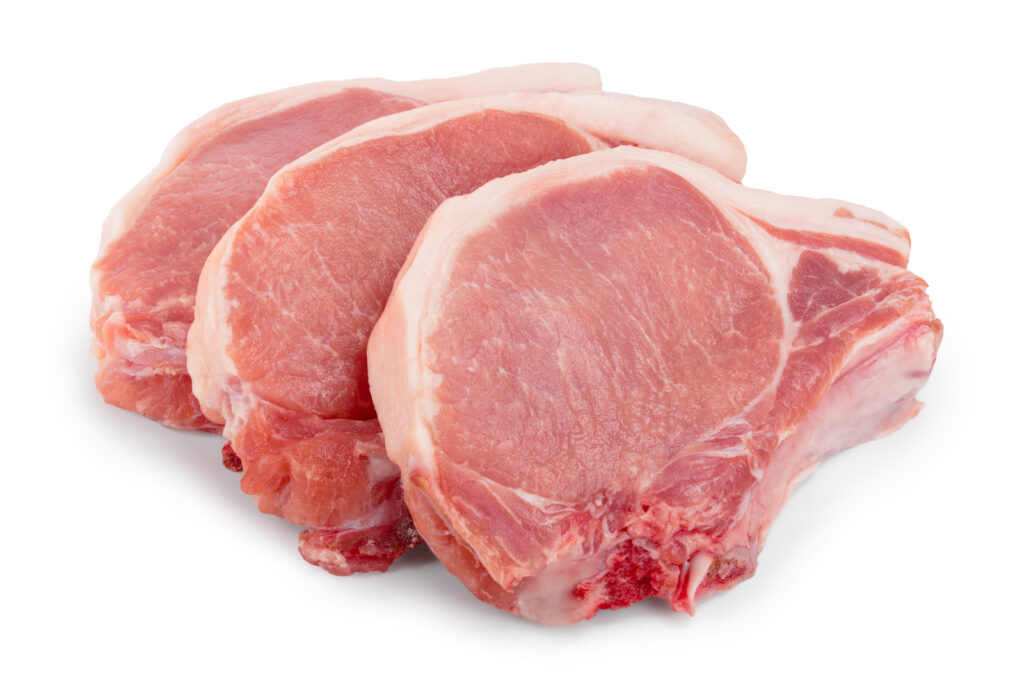 Three raw pork chops on a white background 