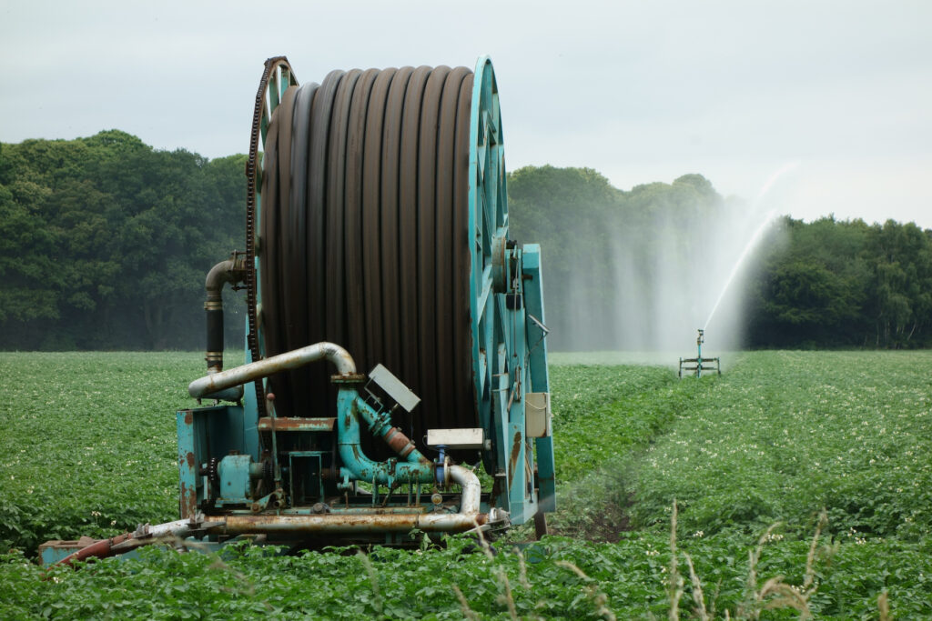 irrigation reel spraying water onto potato field.