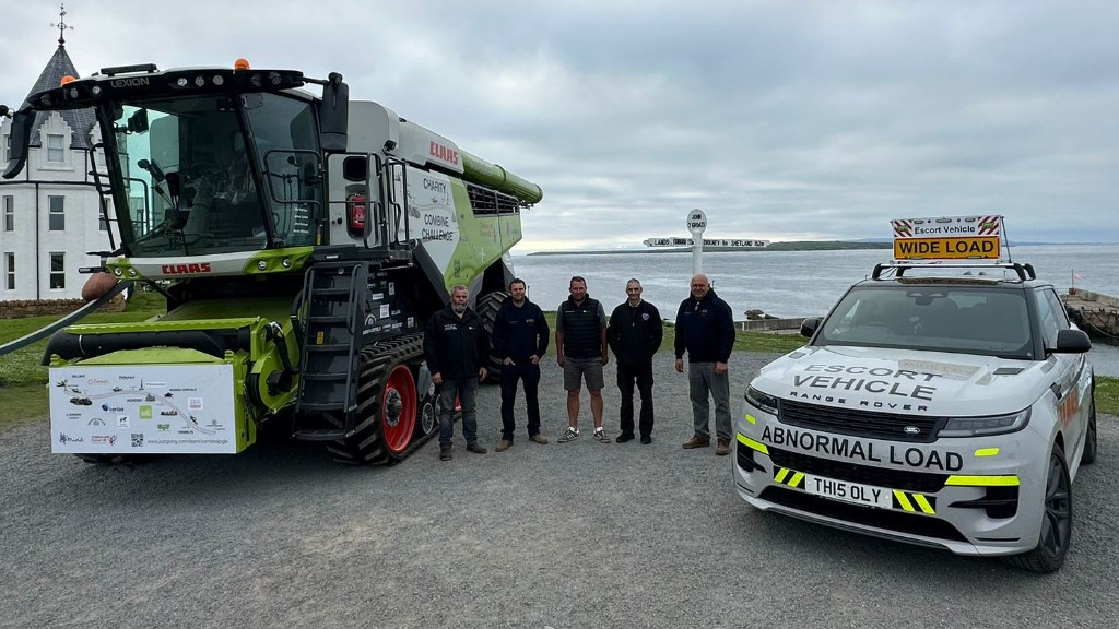 group of farmers stood next to a Claas combine harvester next to the John o Groats sign