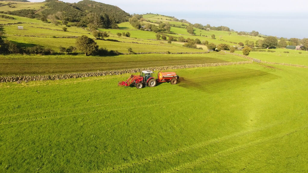 picture of a tractor spreading slurry in a field in the UK.