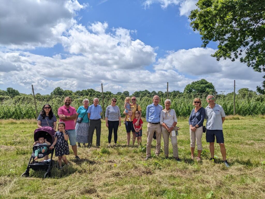 A group of 11 people and two children standing in a field, visiting Hukins Hops for LEAF Open Farm Sunday