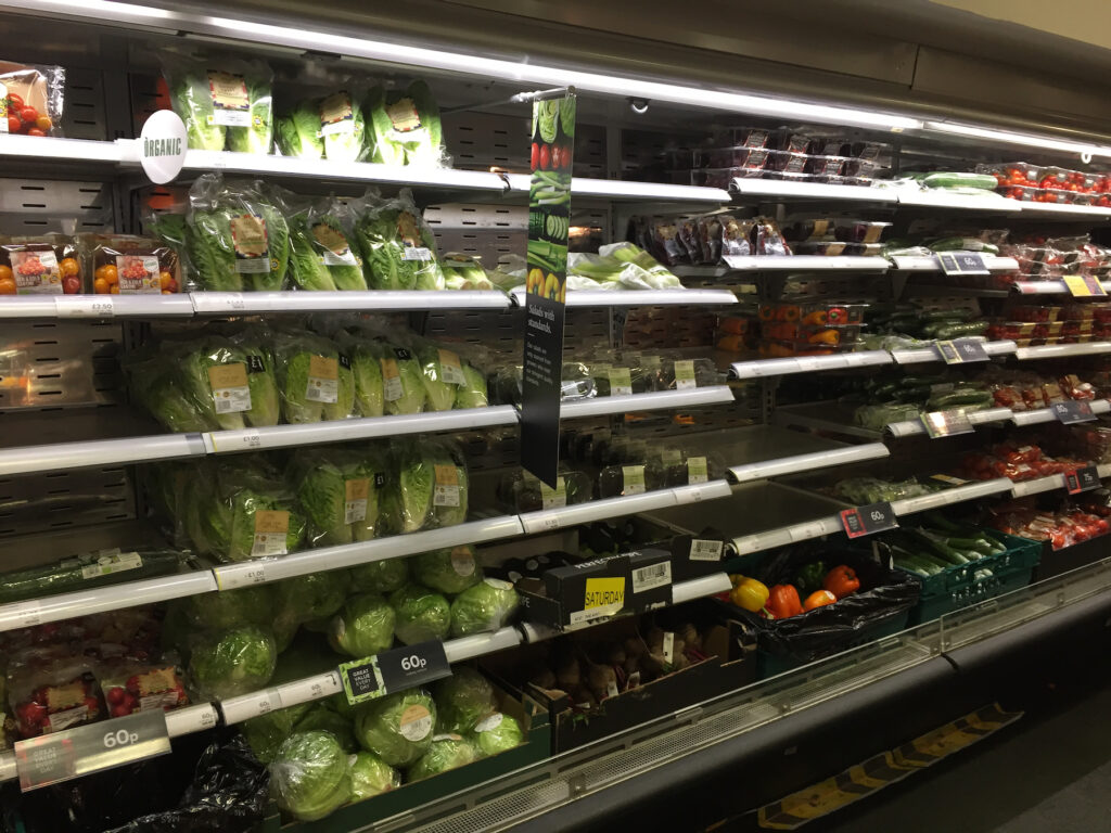 supermarket aisle with fresh fruit and veg
