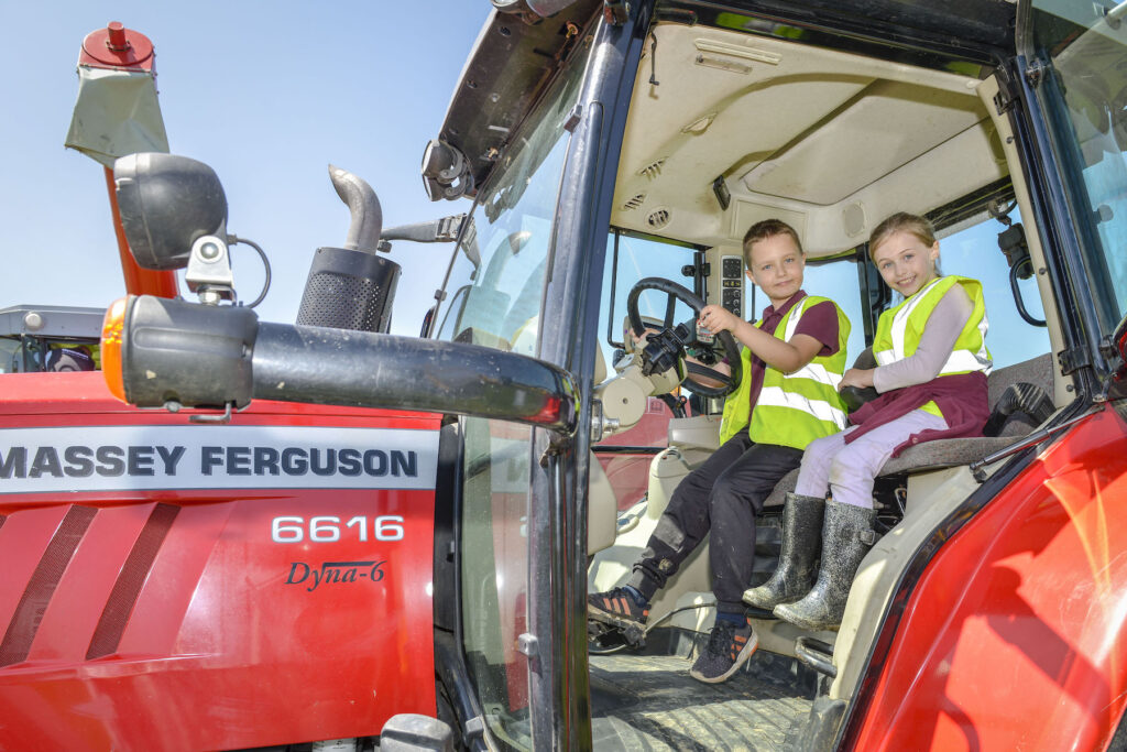 two children in a red Massey Ferguson tractor