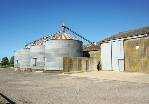 Grain silos on farm in sunny harvest season