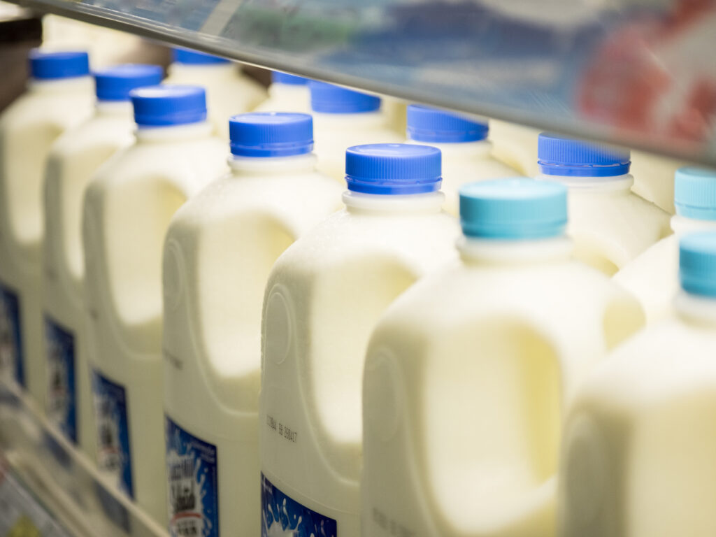 milk bottles lined up in supermarket