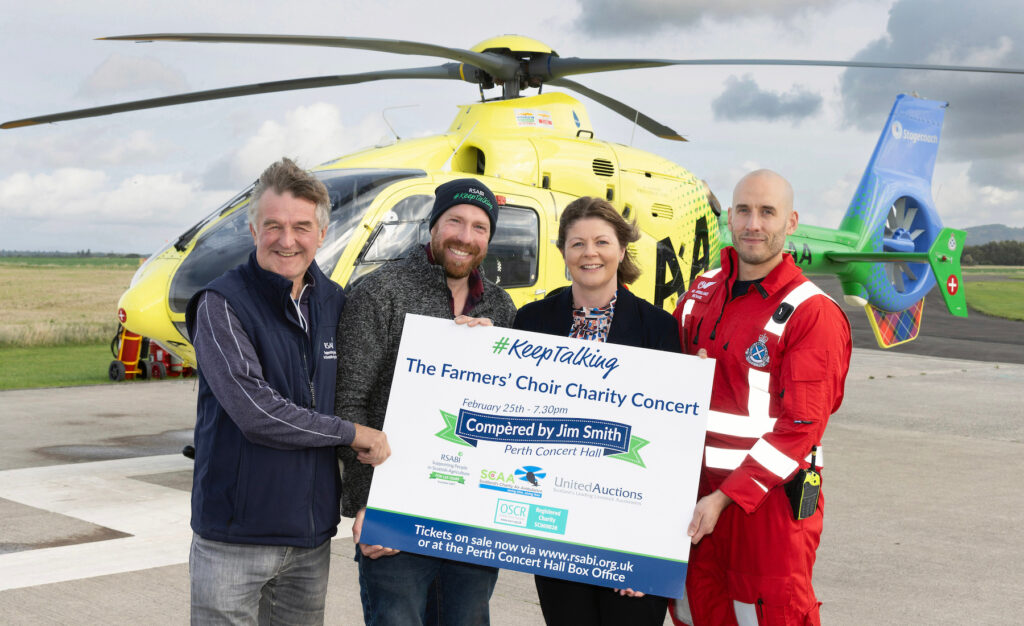Pictured left-right in front of an air ambulance are RSABI chair Jimmy McLean, farmer and concert compère Jim Smith, United Auctions' Judith Murray and SCAA paramedic Michael Haines. They are holding a sign advertising the choir concert