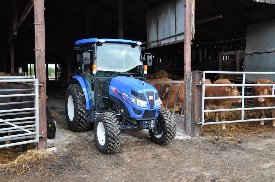 iseki compact tractor pictured coming out of a beef cattle shed