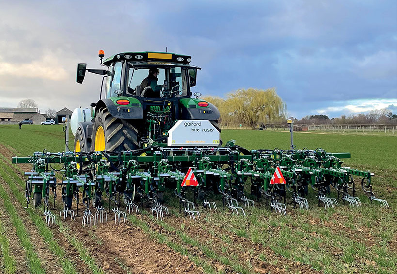 Garford weed control machinery fixed to working tractor in farmer's field