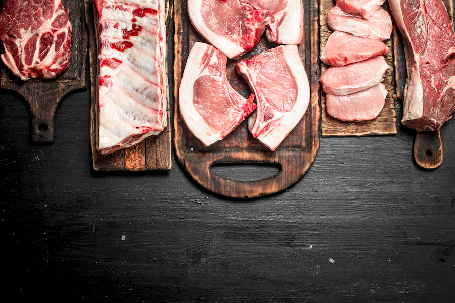 different types of pork meat on chopping boards