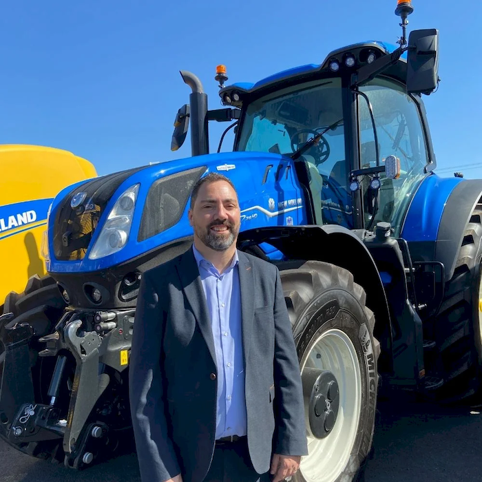 new RVT managing director Shawn Blake in front of New Holland tractor 