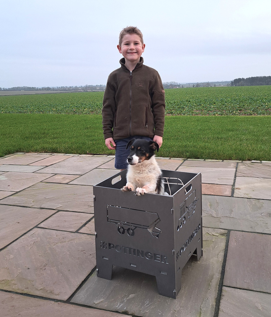 10.	Six-year-old William Tagg from Boston was thrilled to receive his prize – a firepit which was donated by Alois Pottinger. Pictured in the (thankfully unlit) firepit is their dog, Ginny.