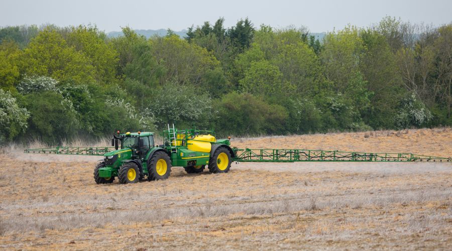 John Deere tractor trailing a sprayer